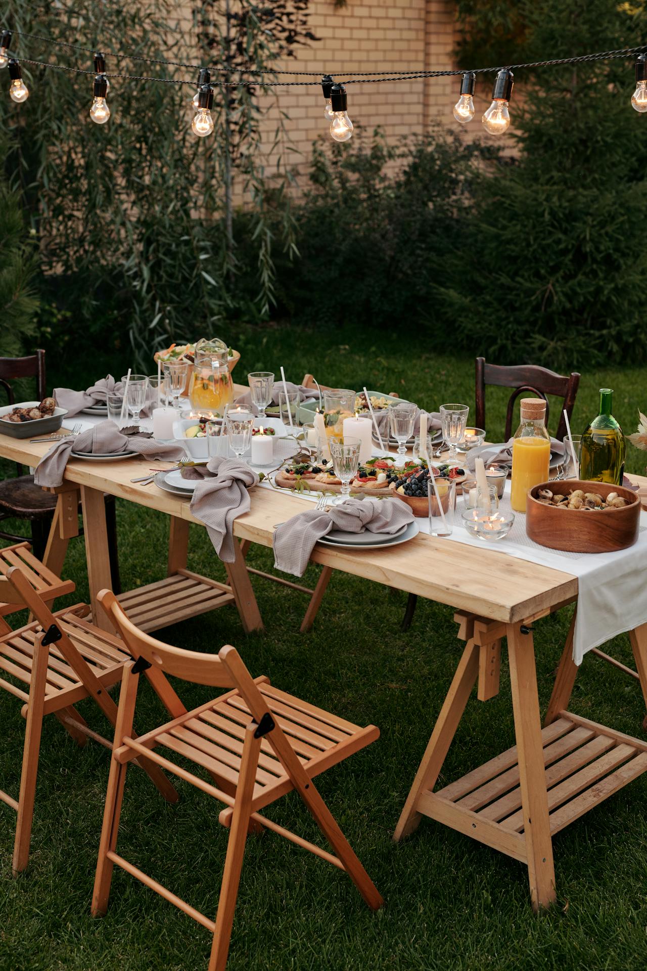 A garden dining area with string fairy lights above it.