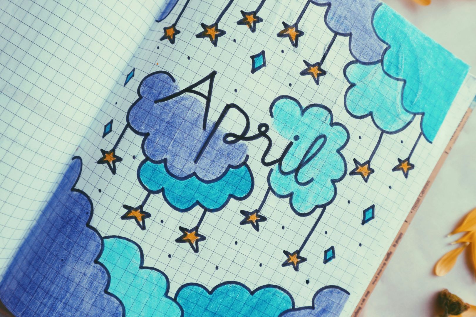 A notebook with pictures of clouds and stars and "April" written over the top.