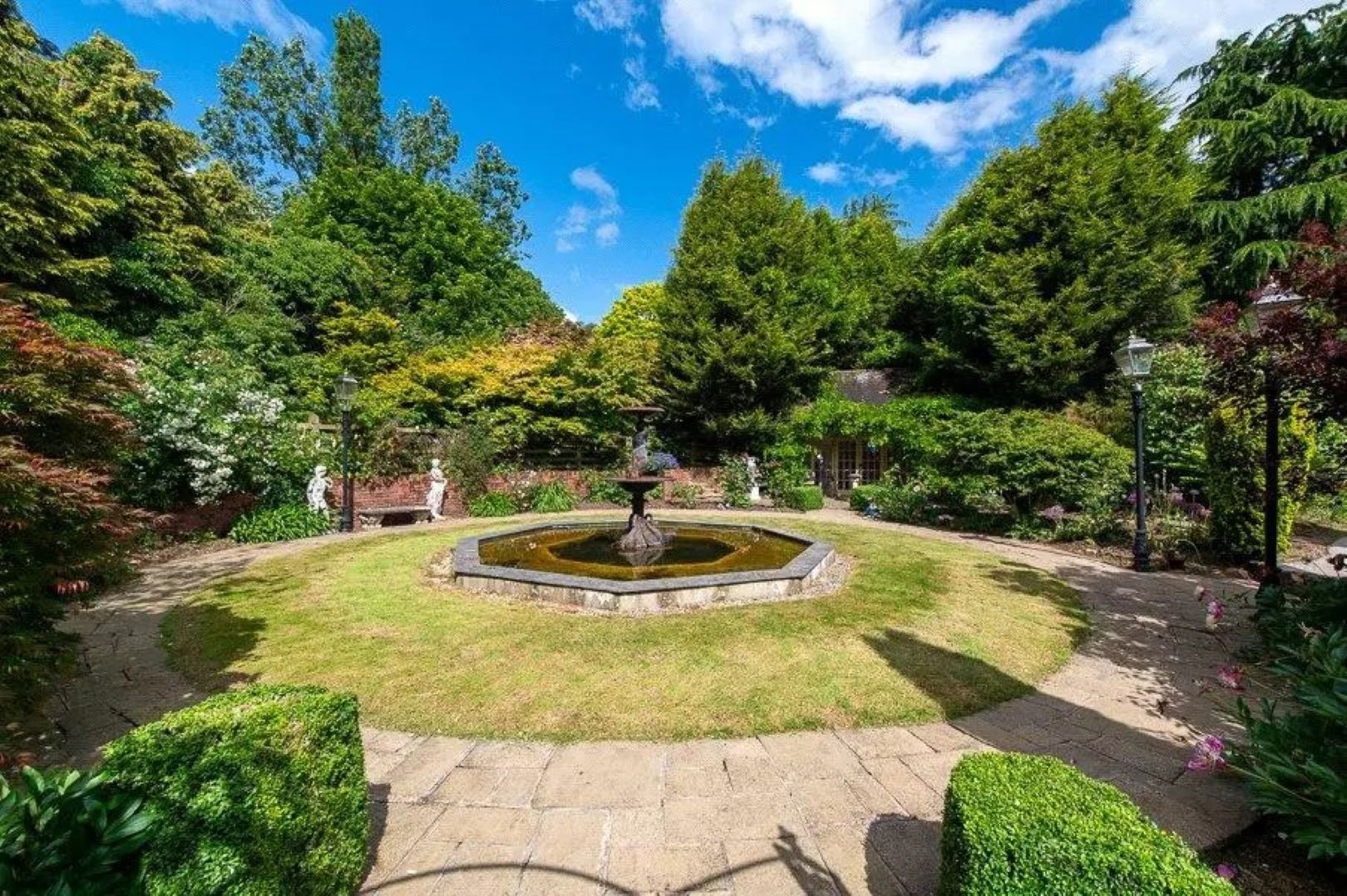 Formal walled garden with a fountain water feature in the centre.
