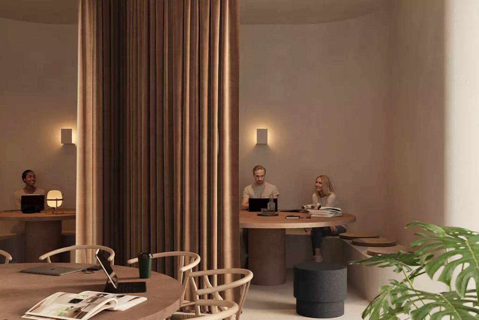 Work space with tables separated by fawn curtains and people working at laptops