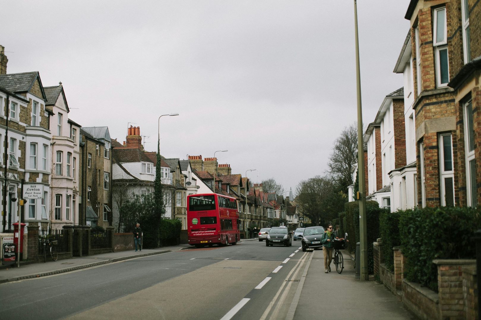 An English street with grey skies, Victorian terraced housing and a red bus