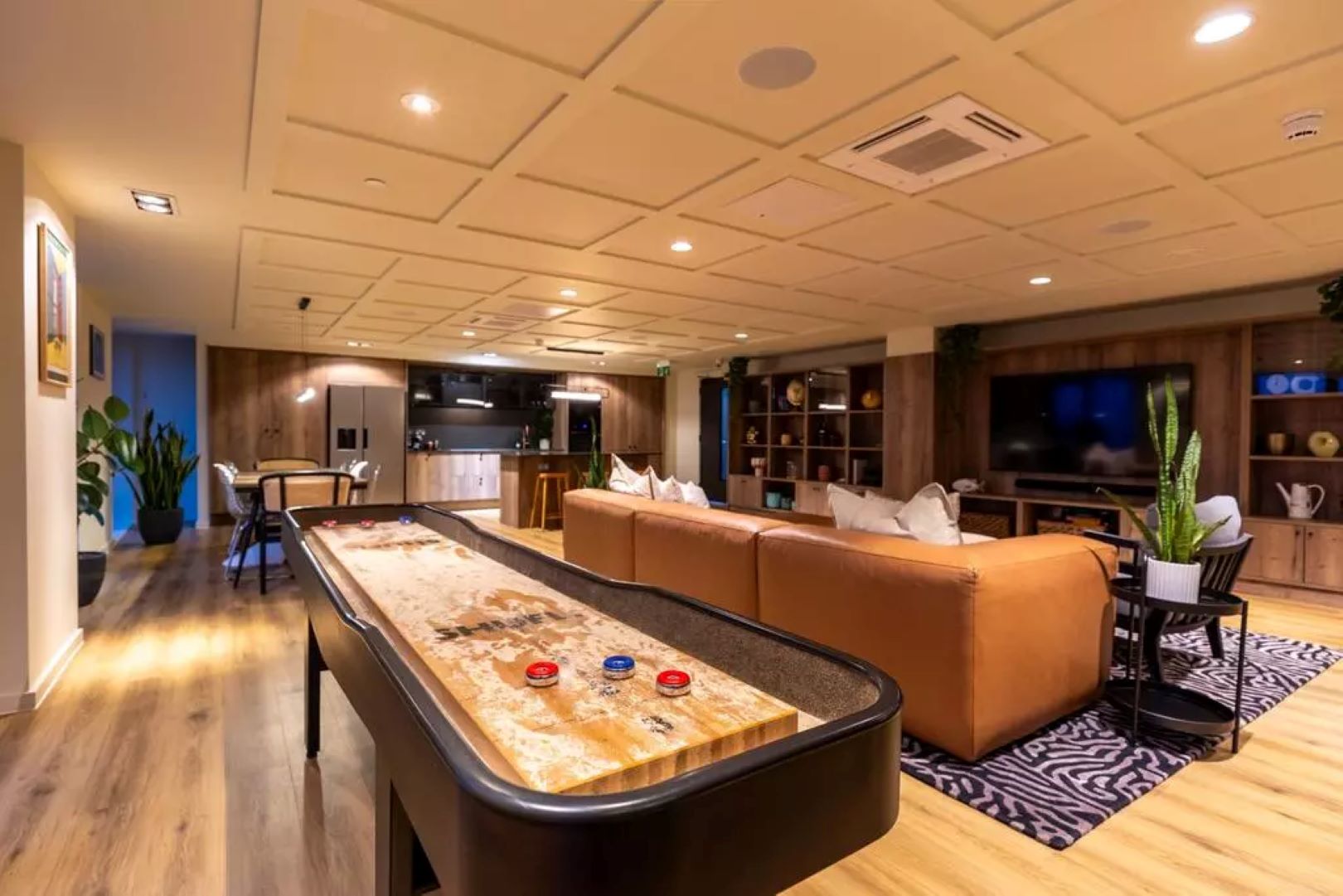 Games room with shuffleboard, sofa and large tv screen