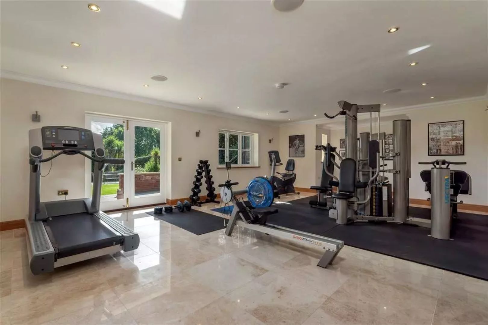 Home gym with treadmill, rowing machine, weight machines and spin bike