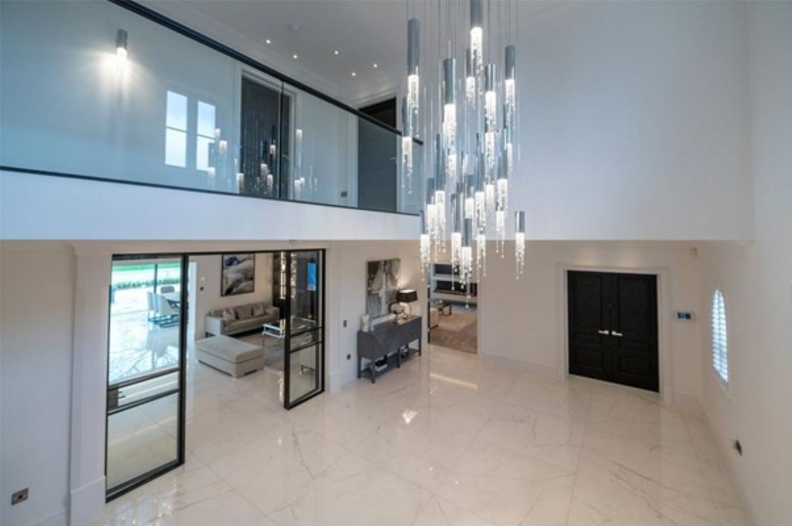 A galleried hallway with long, dangling chandelier