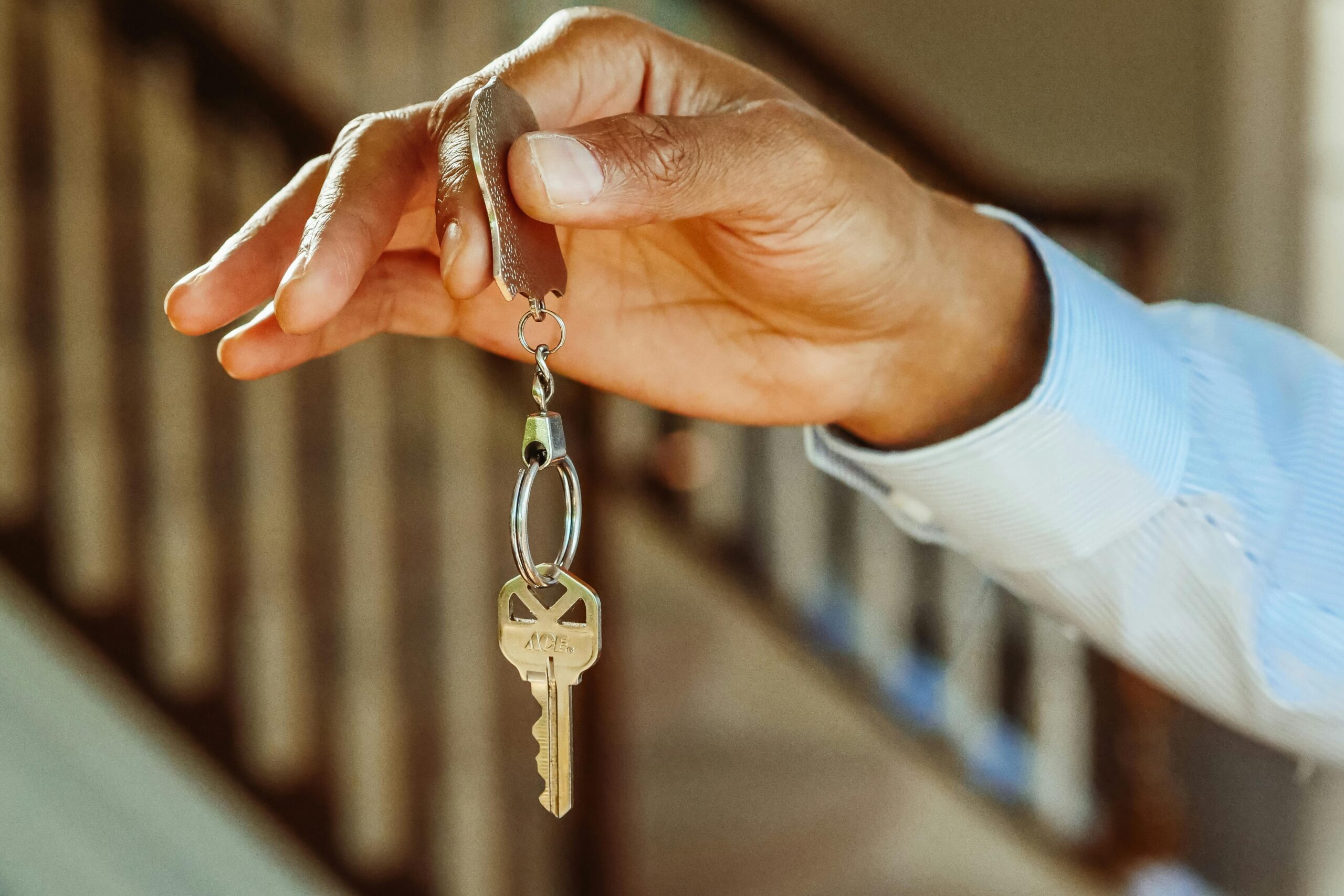 A mans hand holding up a set of house keys.