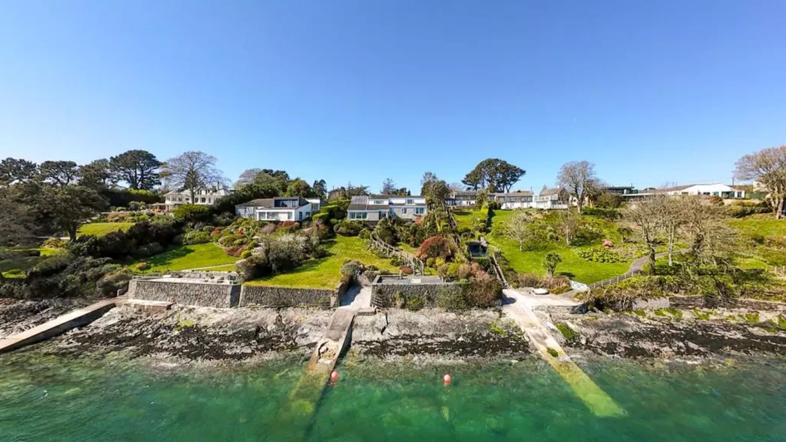 A bank of houses sitting along the water's edge, each with a slipway leading down to the water.